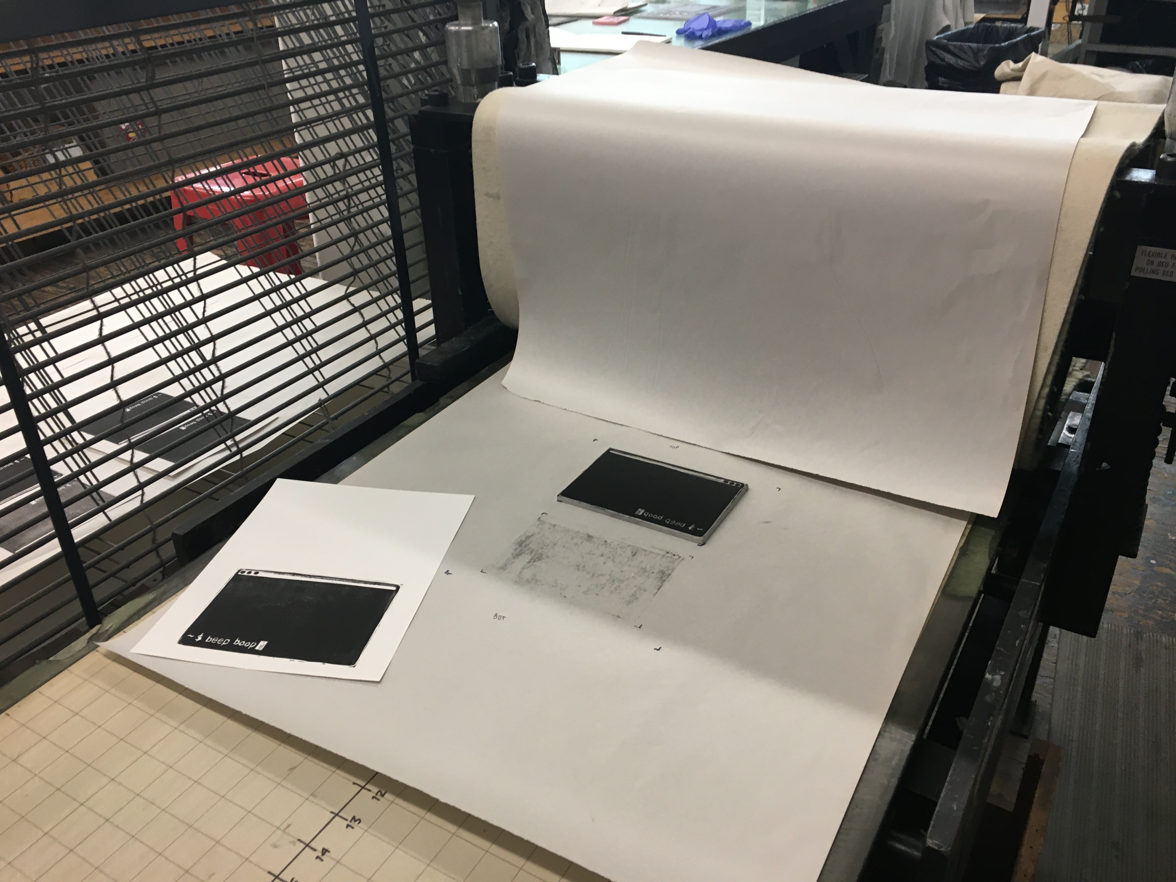 Press bed of a Charles Brand press, with some finished prints on it.